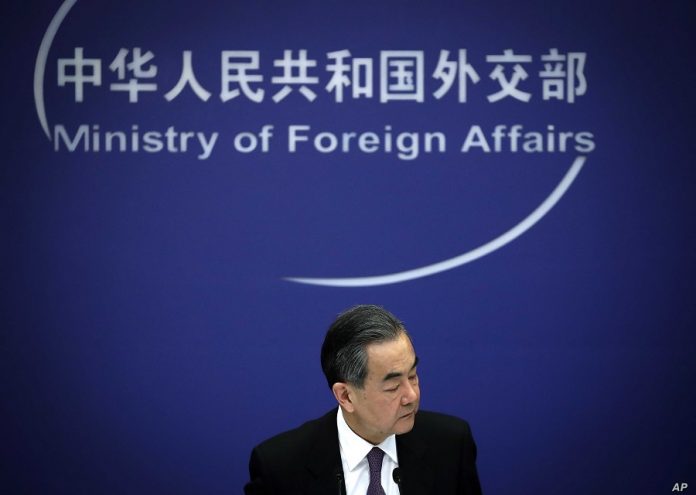 Chinese State Councilor and Foreign Minister Wang Yi reacts during a news conference at the Ministry of Foreign Affairs in Beijing