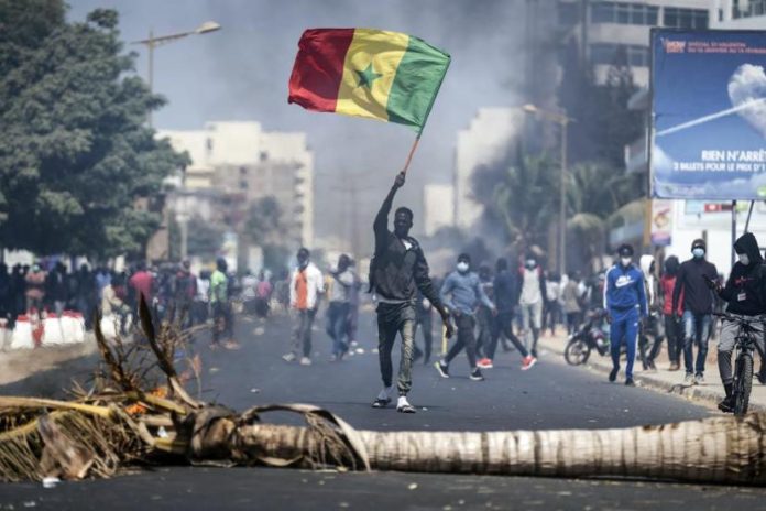 In a file photo, a demonstrator waves a Senegalese national flag during protests in Dakar, Senegal,