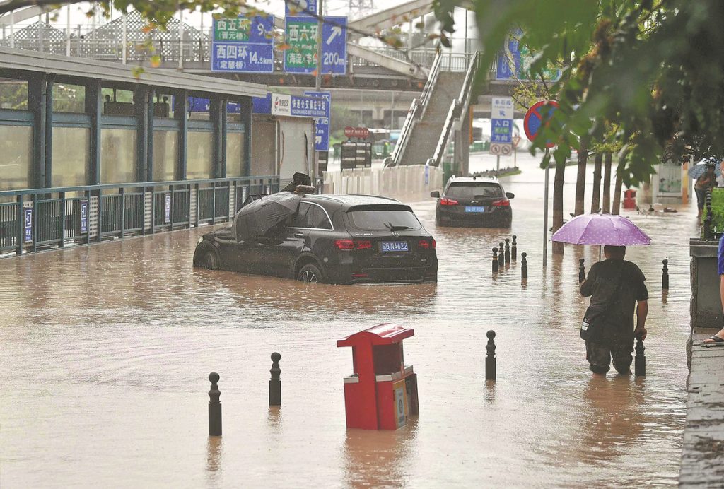 Cars lie stranded on a flooded road in Mentougou district 1