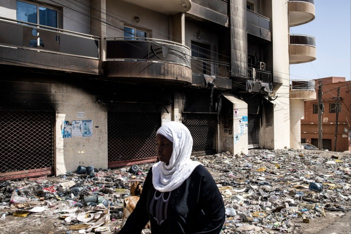 A woman passes a looted and burnt out supermarket in Dakar following violent protests sparked by the arrest of opposition leader Ousmane Sonko © John Wessels AFP Getty Images
