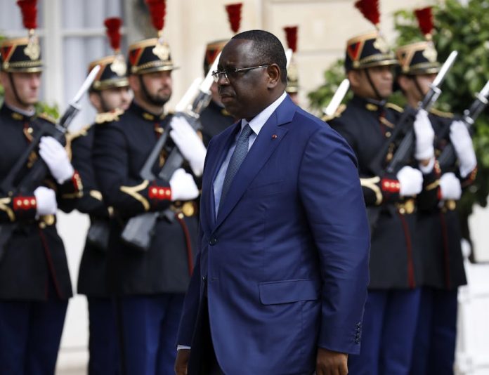 A man in blue suit walk pass a line of soldiers Macky Sall during a visit to the French Elysee presidential palace on 10 June 2022 in Paris. Antoine Gyori_Corbis via Getty Images