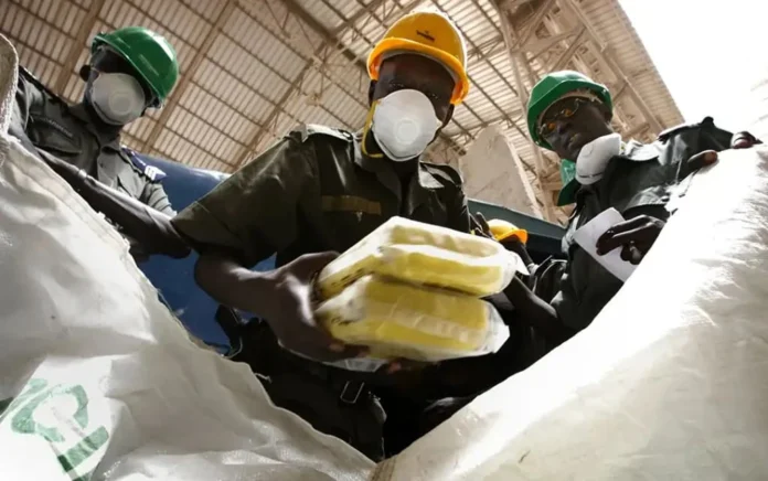 Senegalese soldiers fill a bag with bricks of seized cocaine to be destroyed near Dakar, the national capital. REUTERS